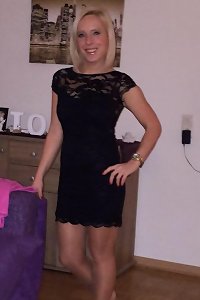 the lovely woman is sitting on the bed playing with her wet stockings